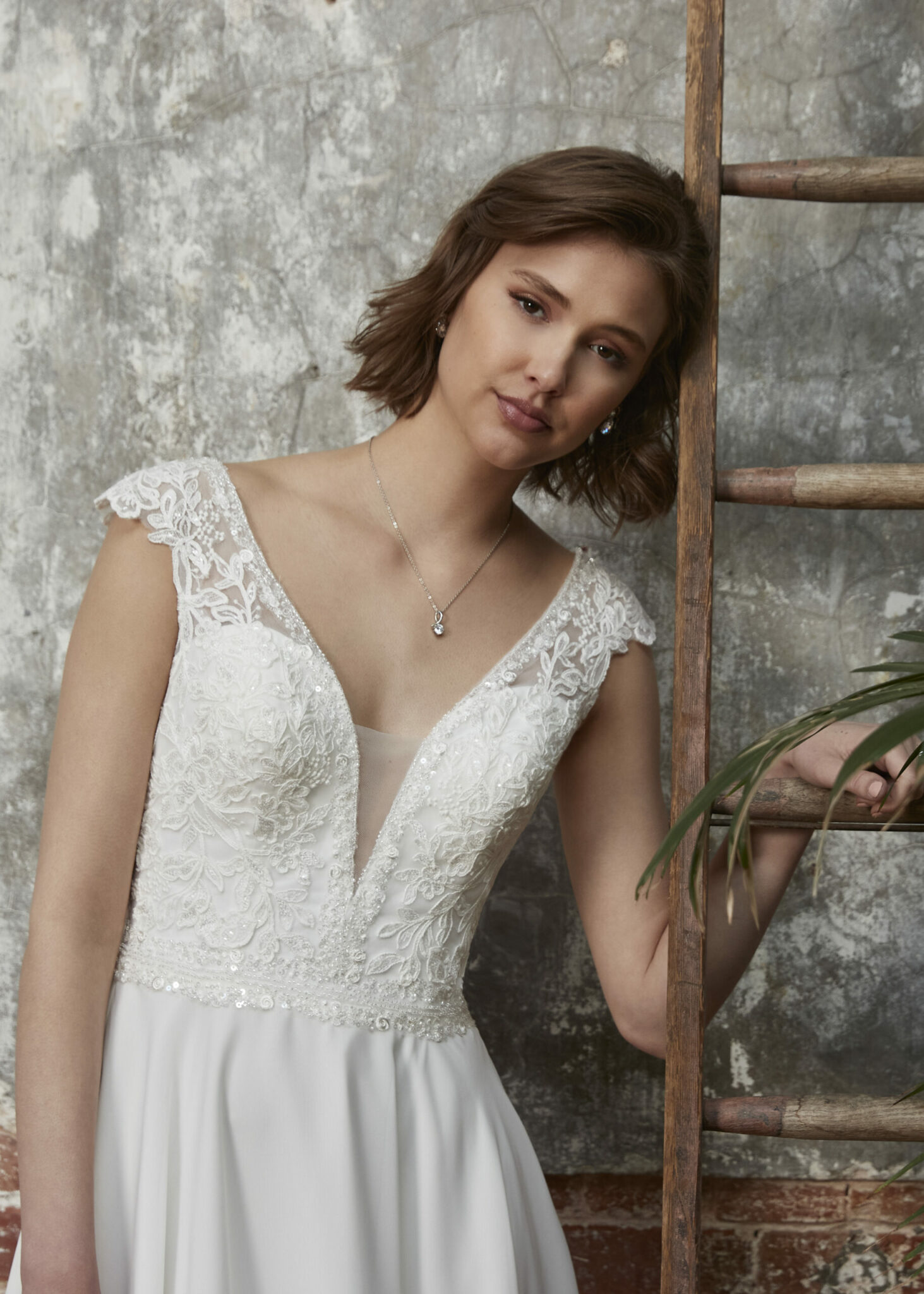 Skye - Skye Fantastic lace cap sleeves lead down into a plunging neckline and Chiffon A-line skirt. Shown in ivory.
